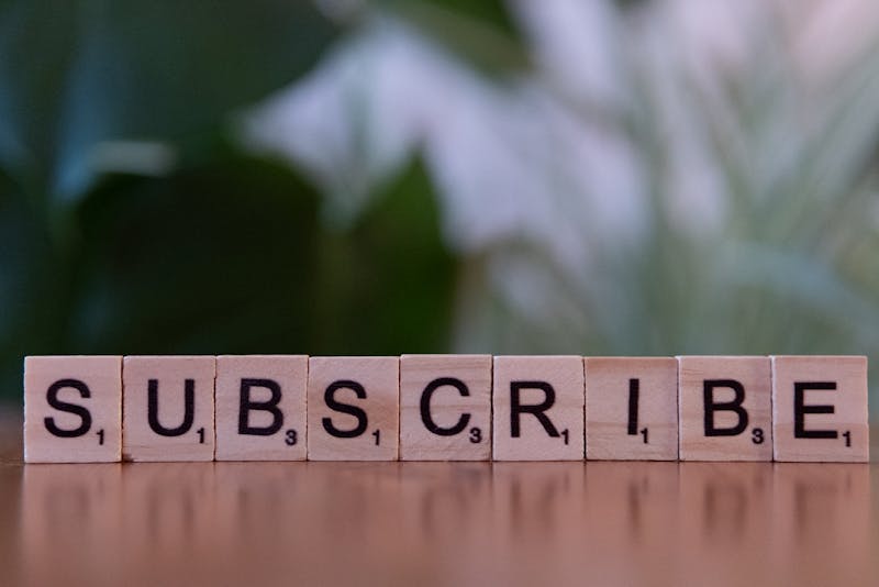 the word subscribe written on small wooden tiles